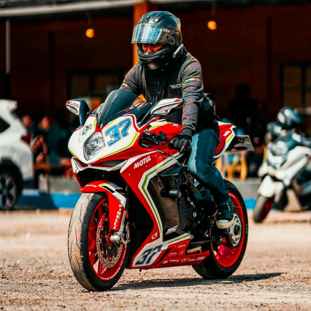 a motorcyclist is riding a red motorcycle down the road