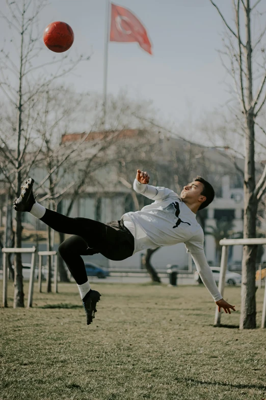 a man in a white jersey catching a red frisbee