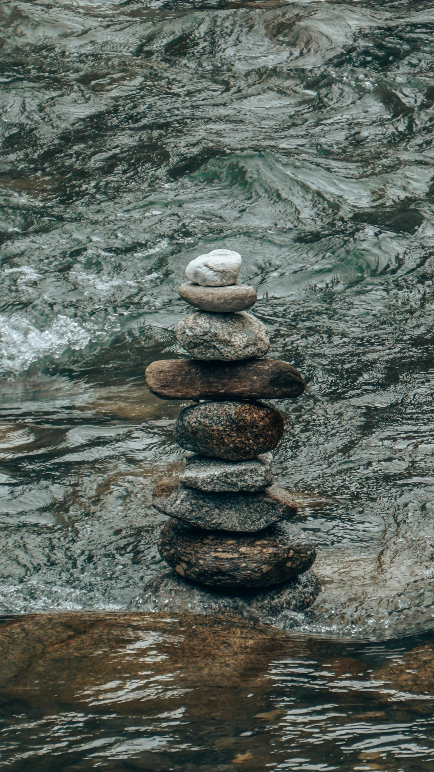 stacked rocks on the ground in a body of water