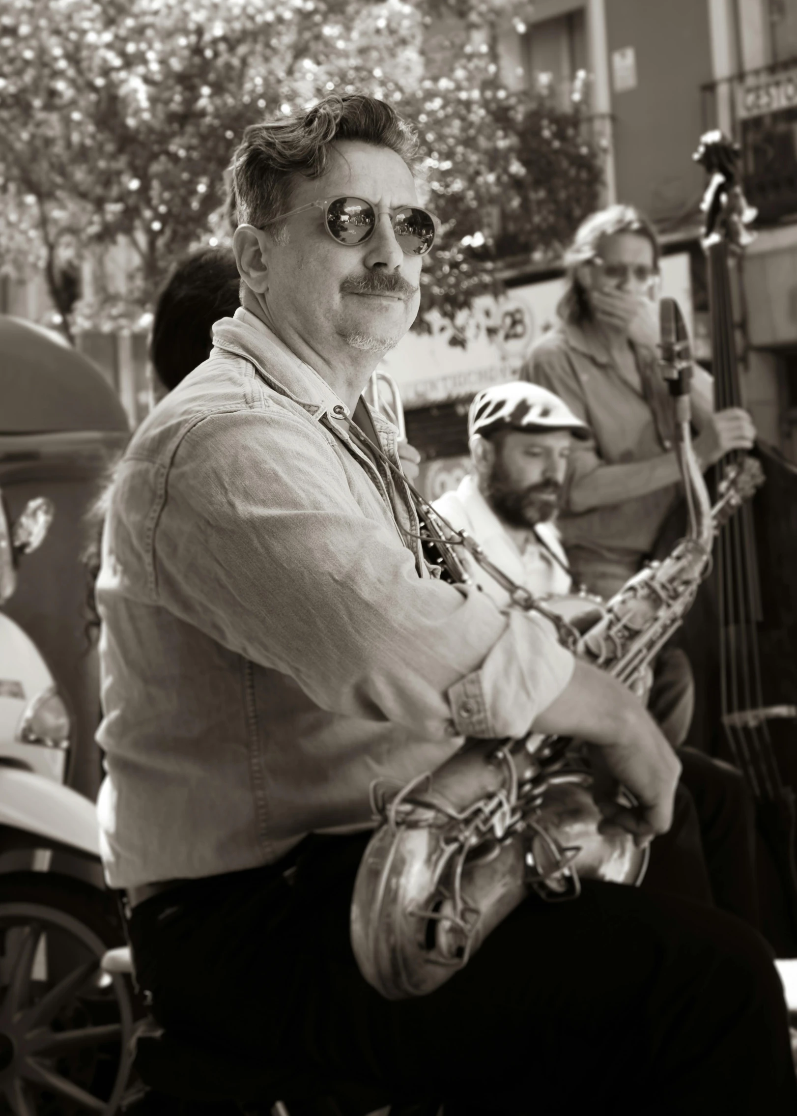 an older man playing a musical instrument while others watch