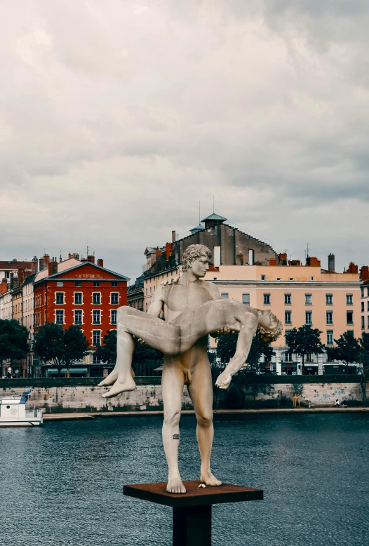 a statue of a man riding a wave is in the middle of a body of water