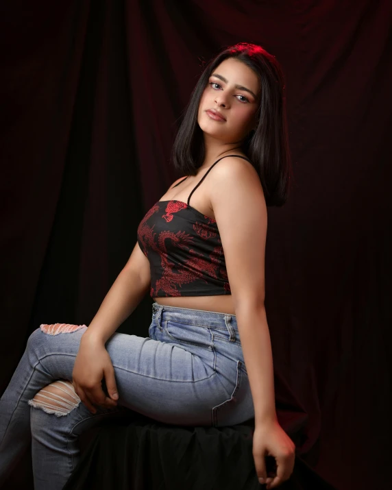 young woman poses with a pair of jeans