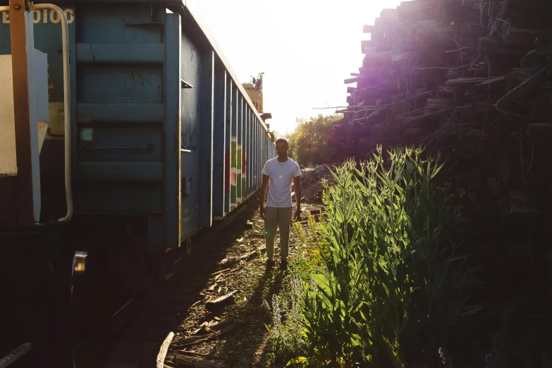 a young man looking on at a passenger train