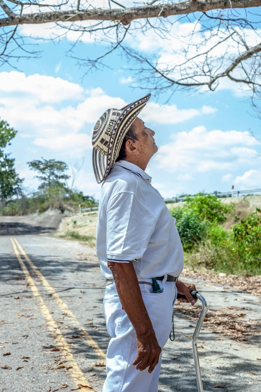 a man wearing a hat while standing on a road