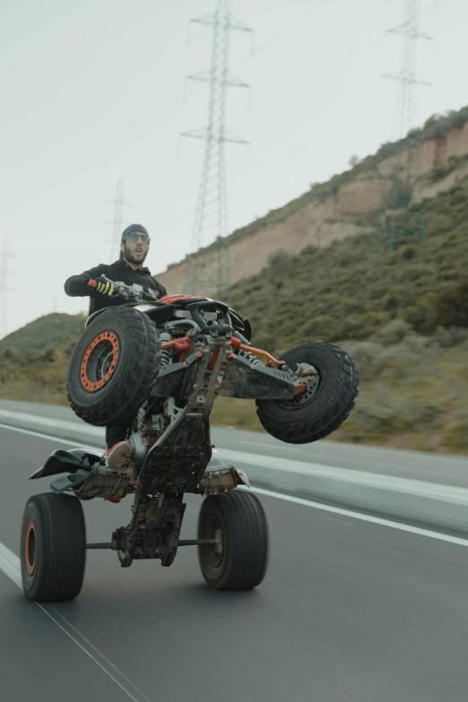 a person on a four - wheeler that is on a road