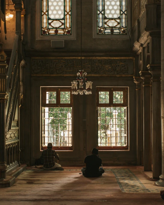 the person in the church is praying under stained glass windows