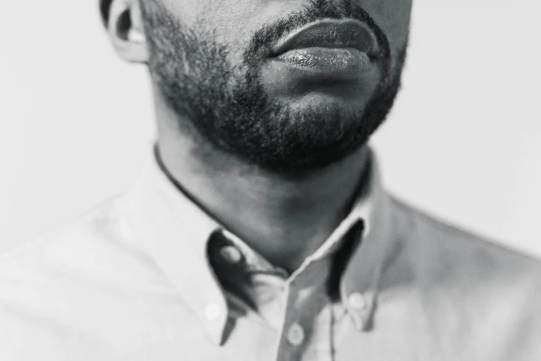 a man poses in front of a white background