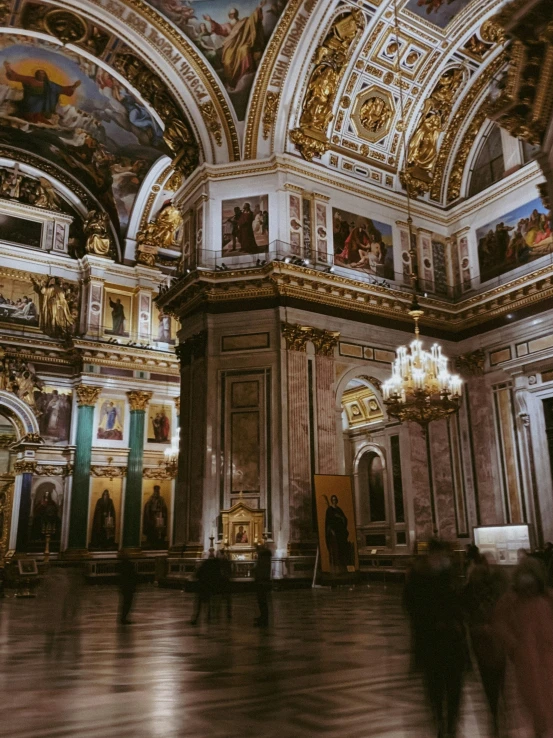 a large ornate ballroom with golden paint and paintings