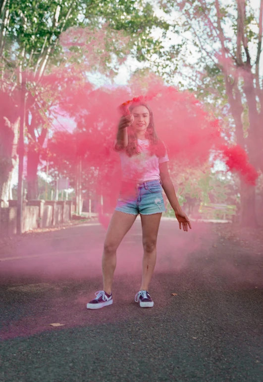 girl holding pink smoke in a park