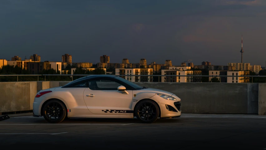 the white sports car is parked in front of a cityscape