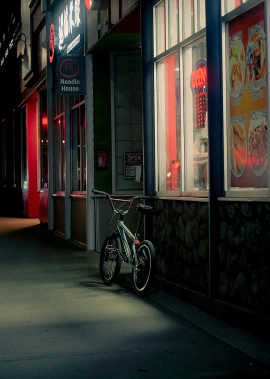 a bike is parked outside the eatery on a street