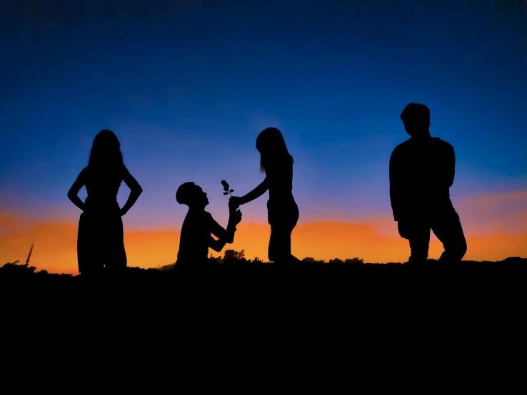 silhouettes of people stand next to each other and laugh