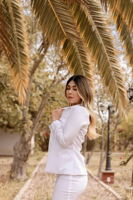 the woman is posing in front of a tree