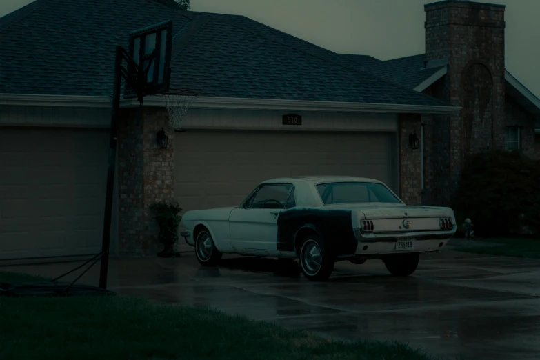 an old car is parked outside in the driveway