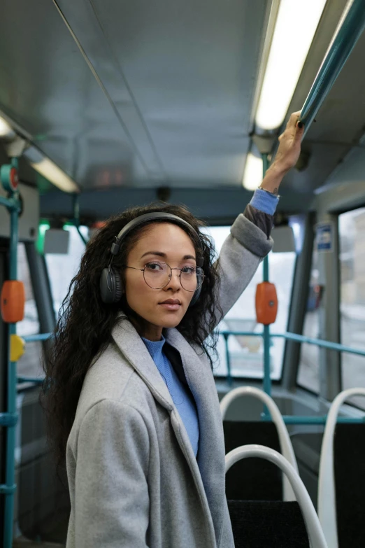 a woman holding a book in her hand riding a bus