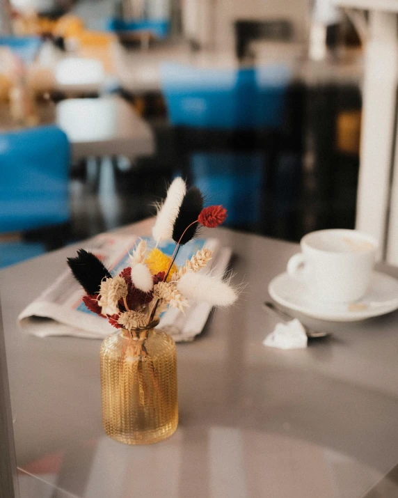 a table that has some flowers in a glass vase on it