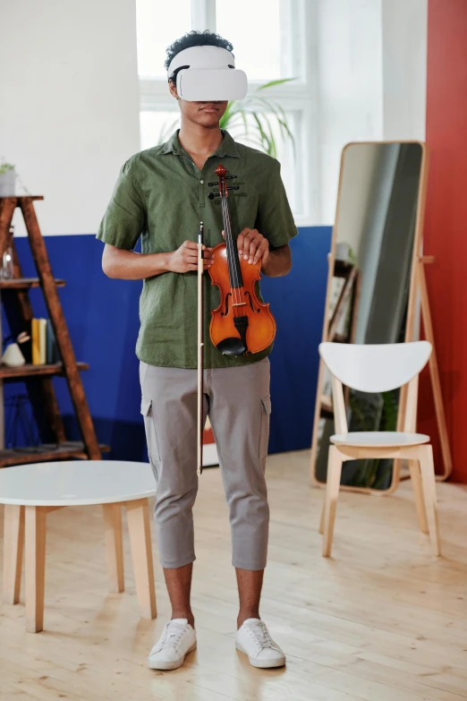 a man is standing in a room with his violin and a virtual headset