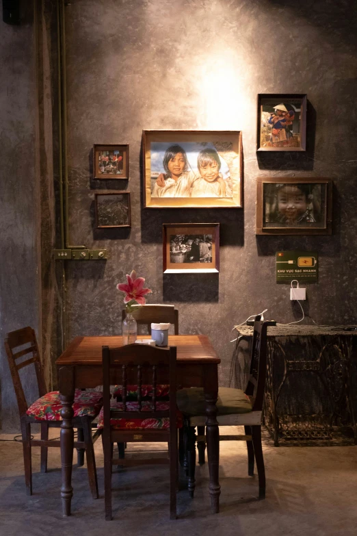 some picture's and paintings on a wall by a table