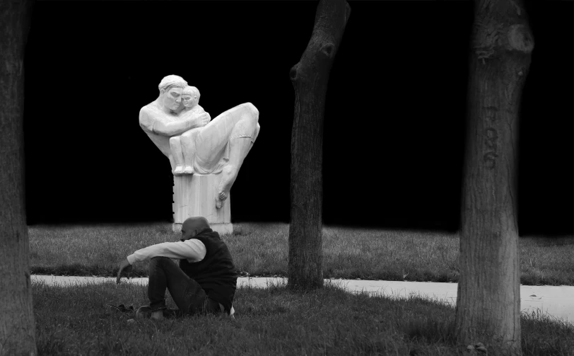 two men kneeling down to look at a statue