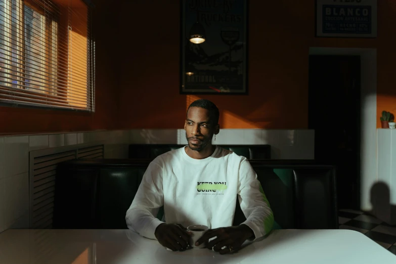 a man in a white shirt sits at a table
