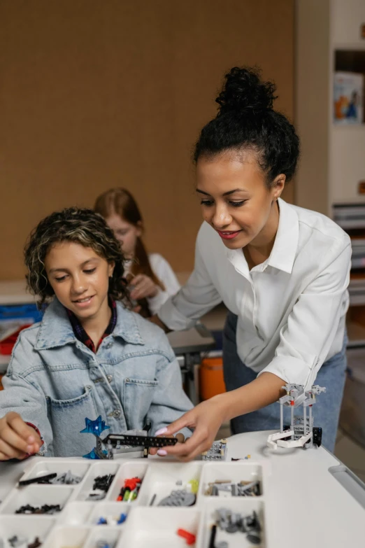 the woman is helping a girl make some crafts