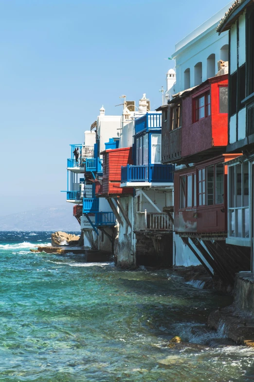 the tall buildings are very colorful next to the ocean