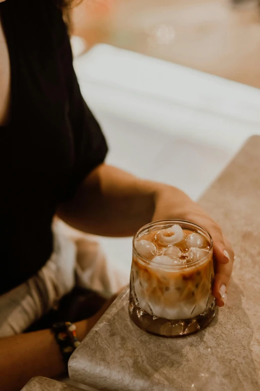 a person holds up a glass on a counter