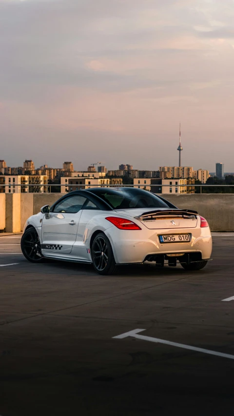 a white sports car driving down a road