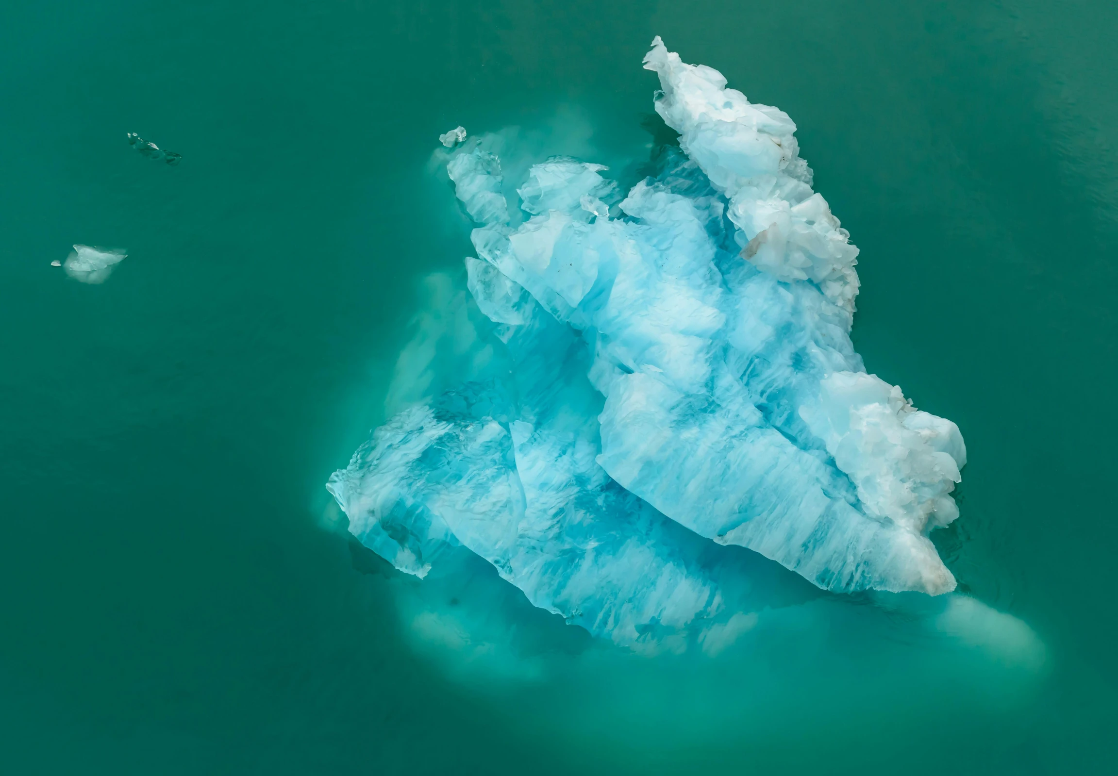 an iceberg with two birds flying about it