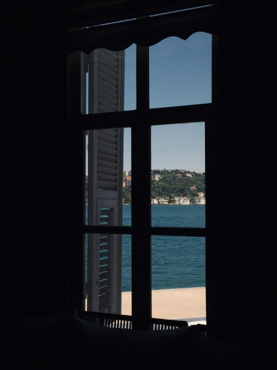 an open window showing a view of the beach