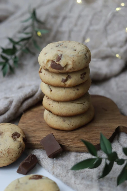 several chocolate chip cookies sitting on top of a wooden platter