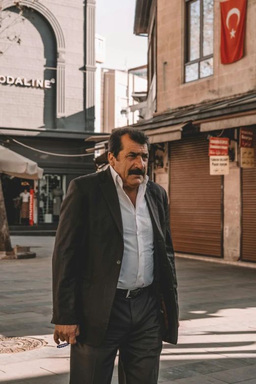 a man in black jacket and white shirt on a street