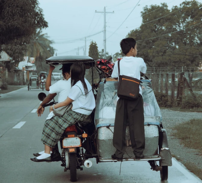 two s in school uniform driving a motorcycle