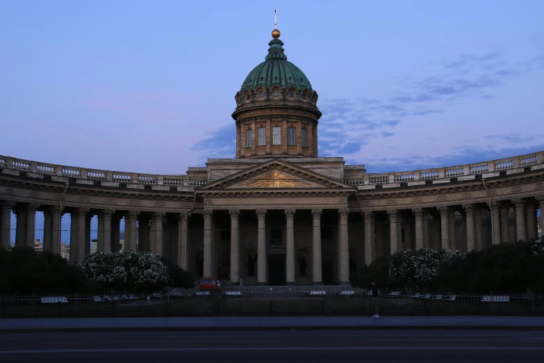 a large building with a dome sits at dusk