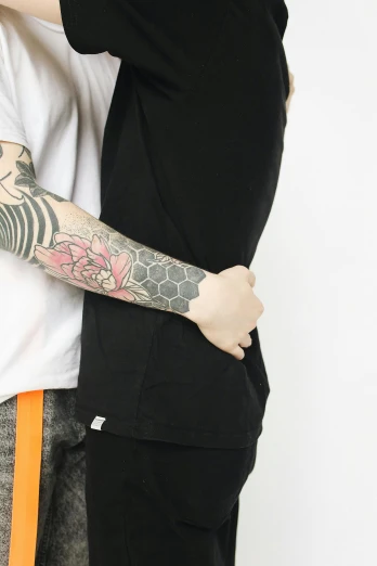 a guy is holding a girl and they both have tattoos