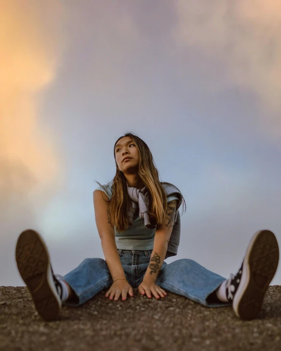 a girl sitting on the ground with her legs crossed