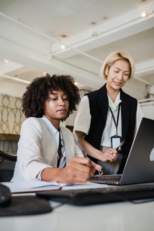 two women looking at a computer together