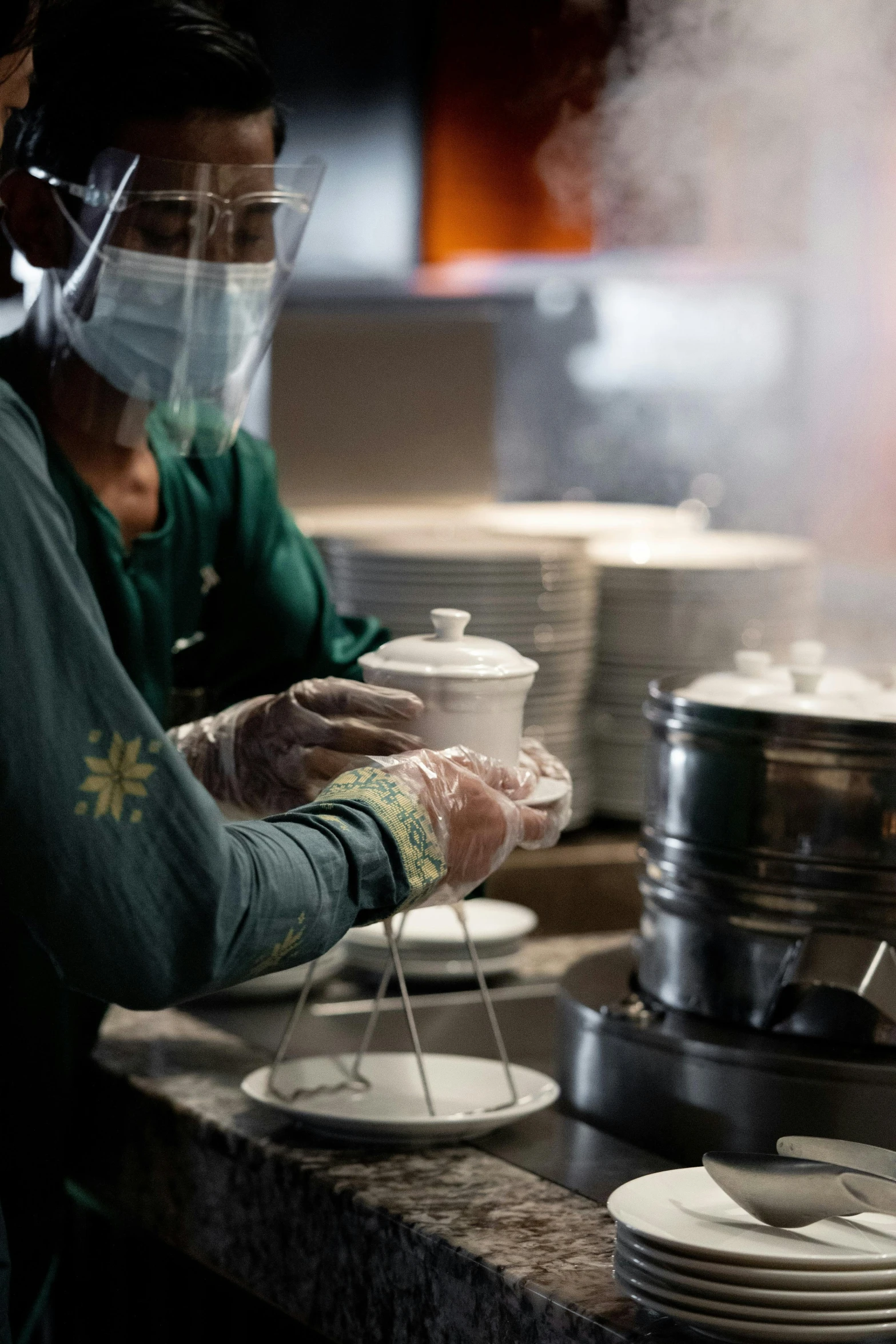 several people with surgical masks, wearing gloves, and plates