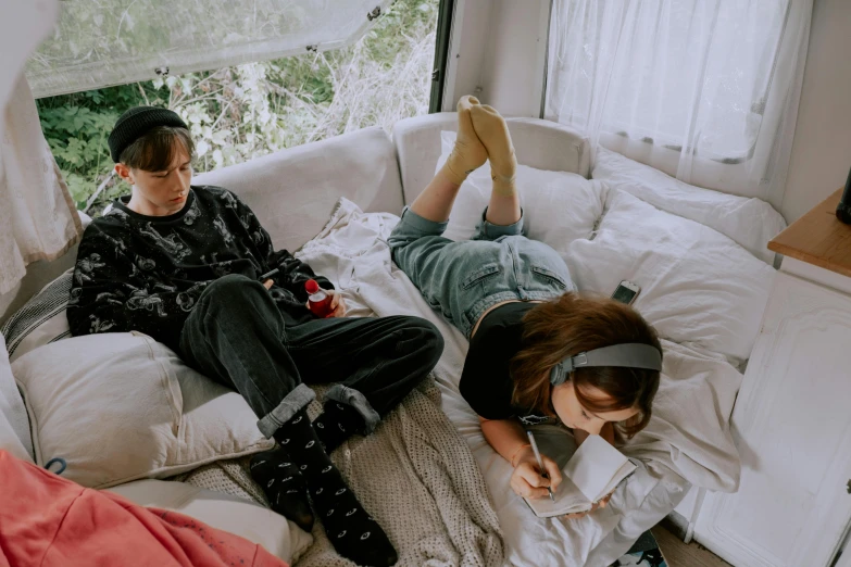 two men and a woman lounging on the couch with their legs crossed