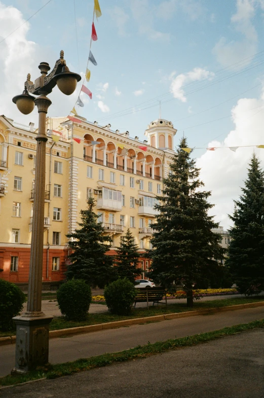 a streetlight and some flags outside a tall building