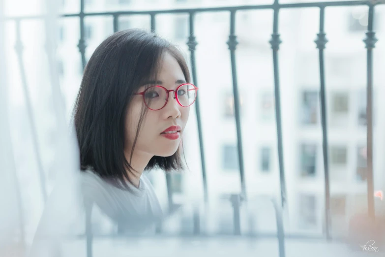 a beautiful woman with glasses sitting by a balcony