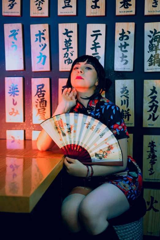 a woman is sitting with an oriental style fan