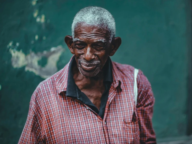 a man in red and white shirt standing with grey hair