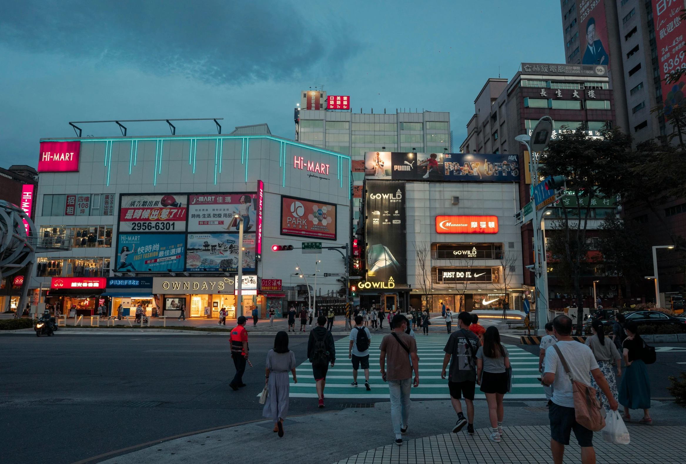 many people are walking across the street on a very crowded city