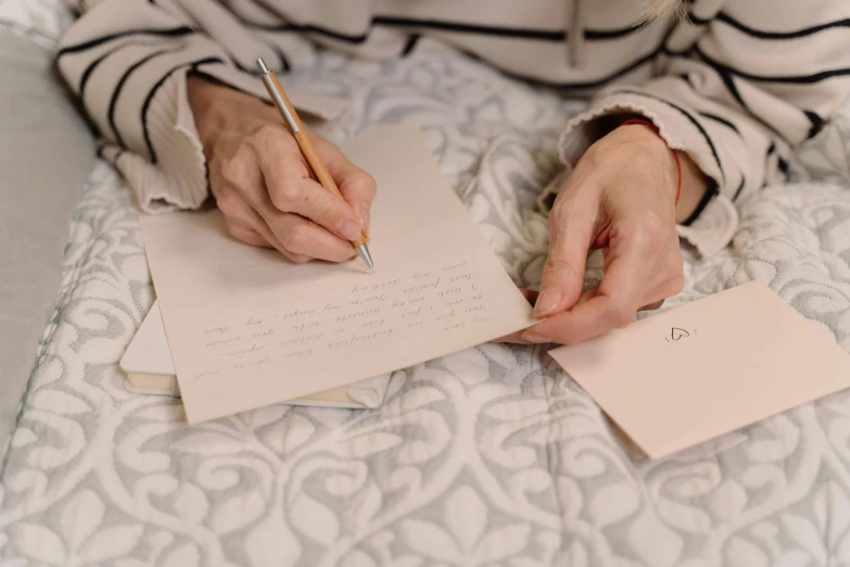 a woman is writing on a notepad with pen