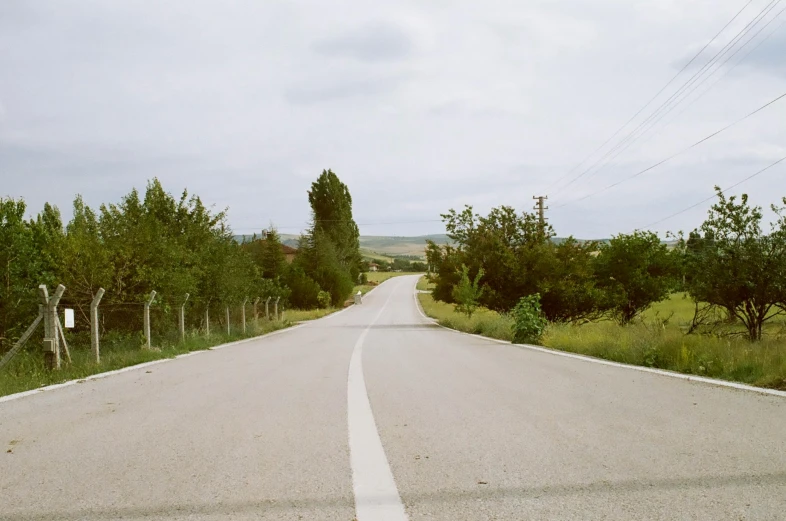 an empty paved road with a sign in the center