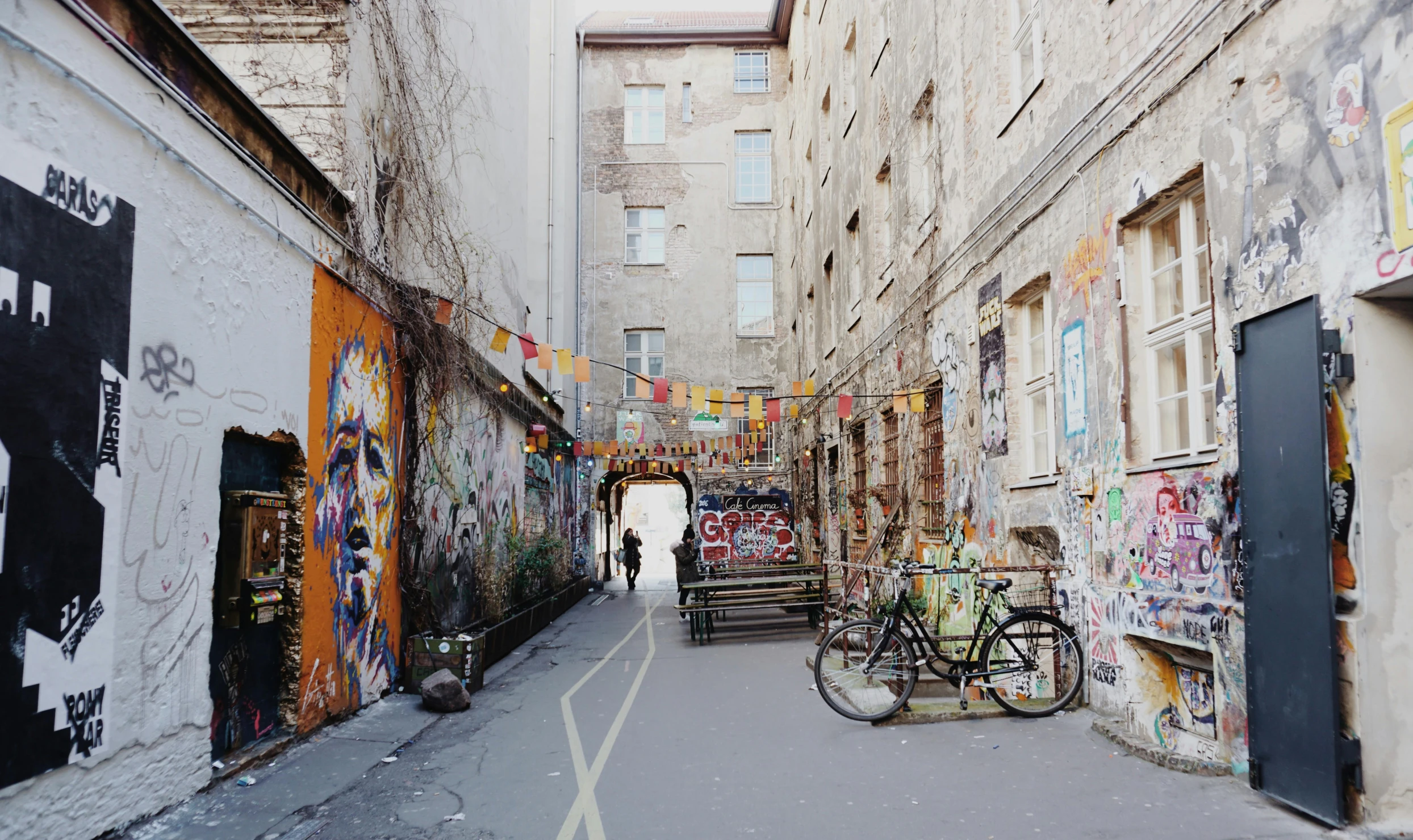 the alley is covered with many graffiti and old buildings