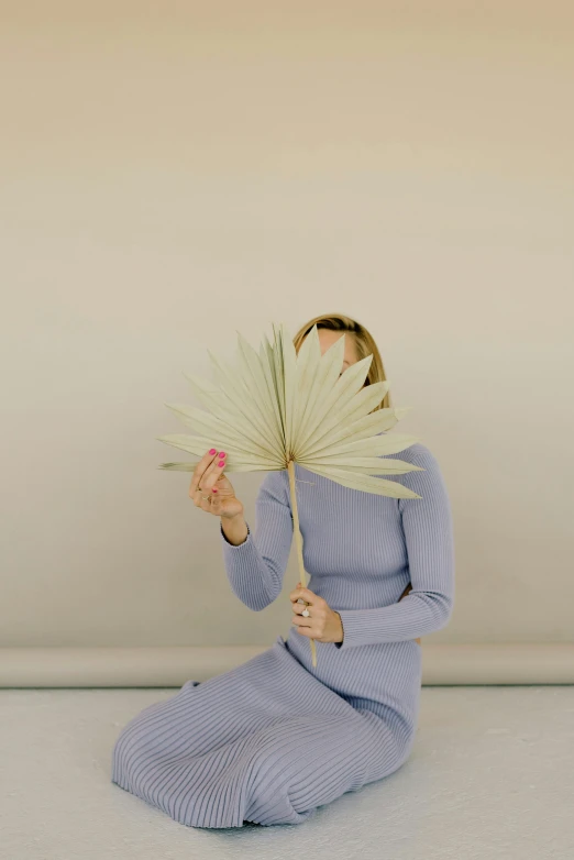 a woman in a dress holding a flower