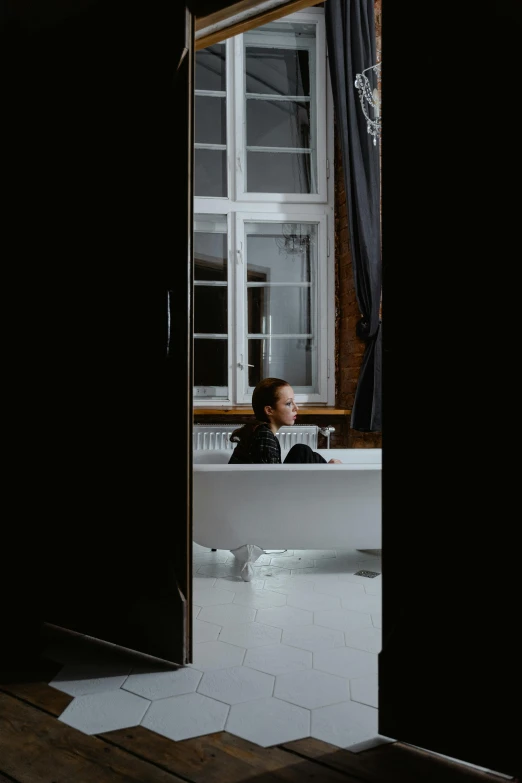 woman laying down in bathtub with window open