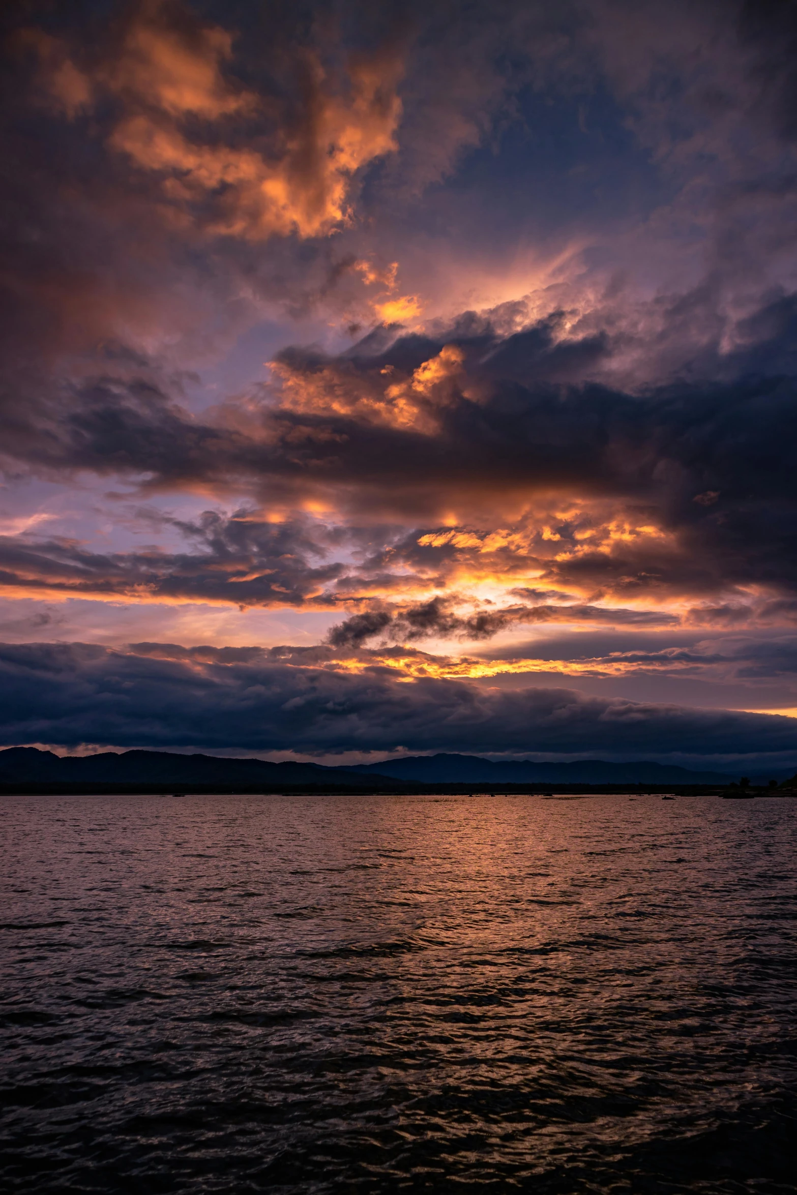 a large body of water with clouds floating in the sky